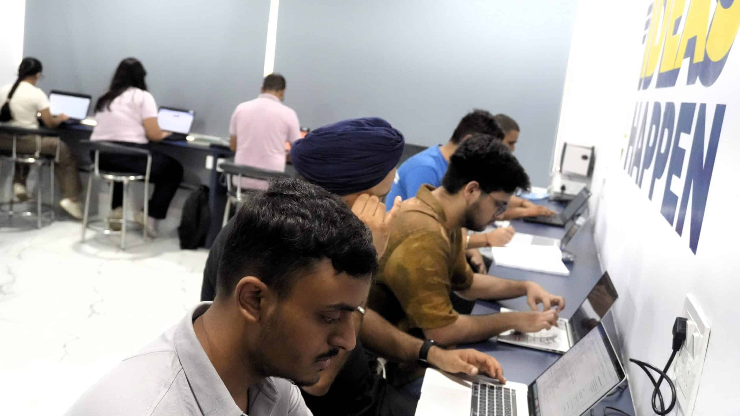 Laptops and students working in a tech-focused classroom at Techno Tykes.