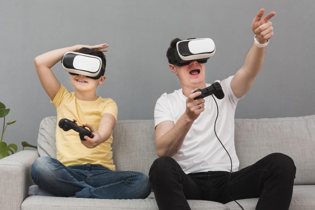 Children and adult enjoying virtual reality gaming together at home.
