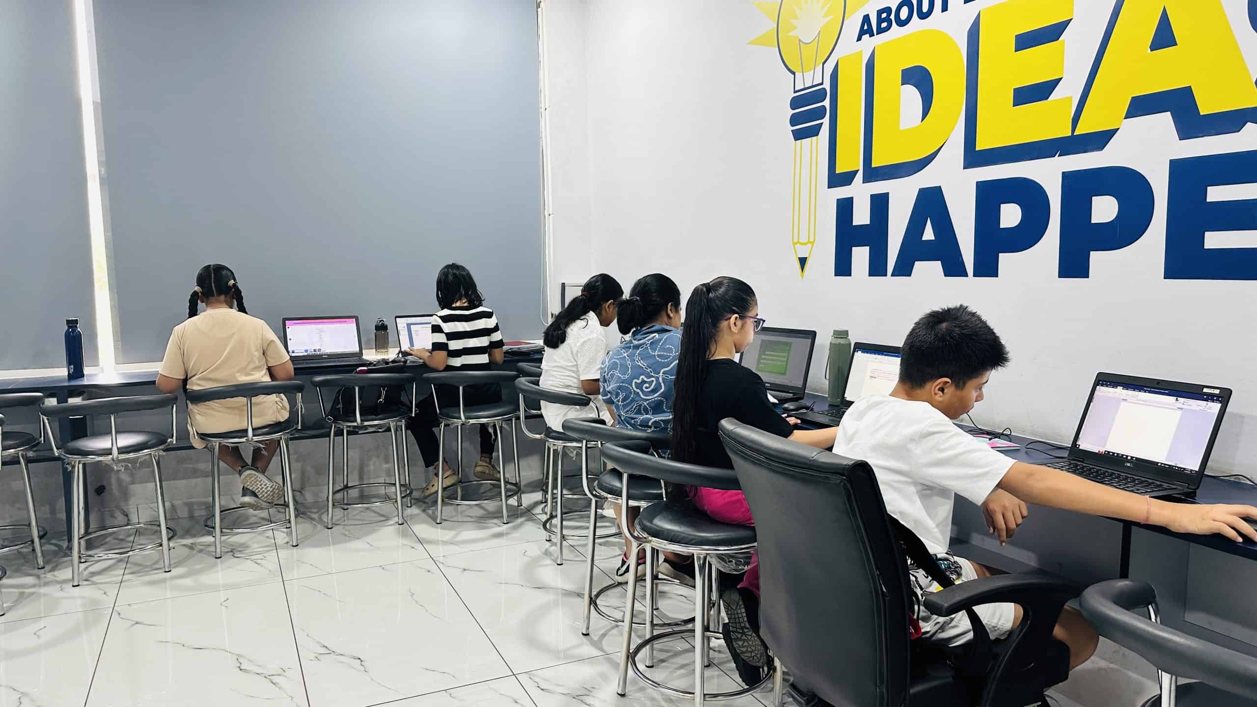 Children working on laptops in a classroom at Techno Tykes.